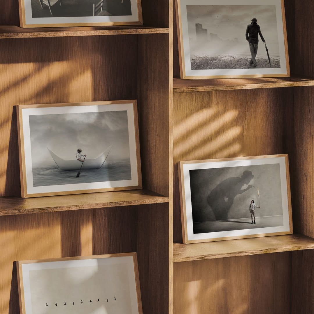 Småformatsaffischer i ramar i en bokhylla