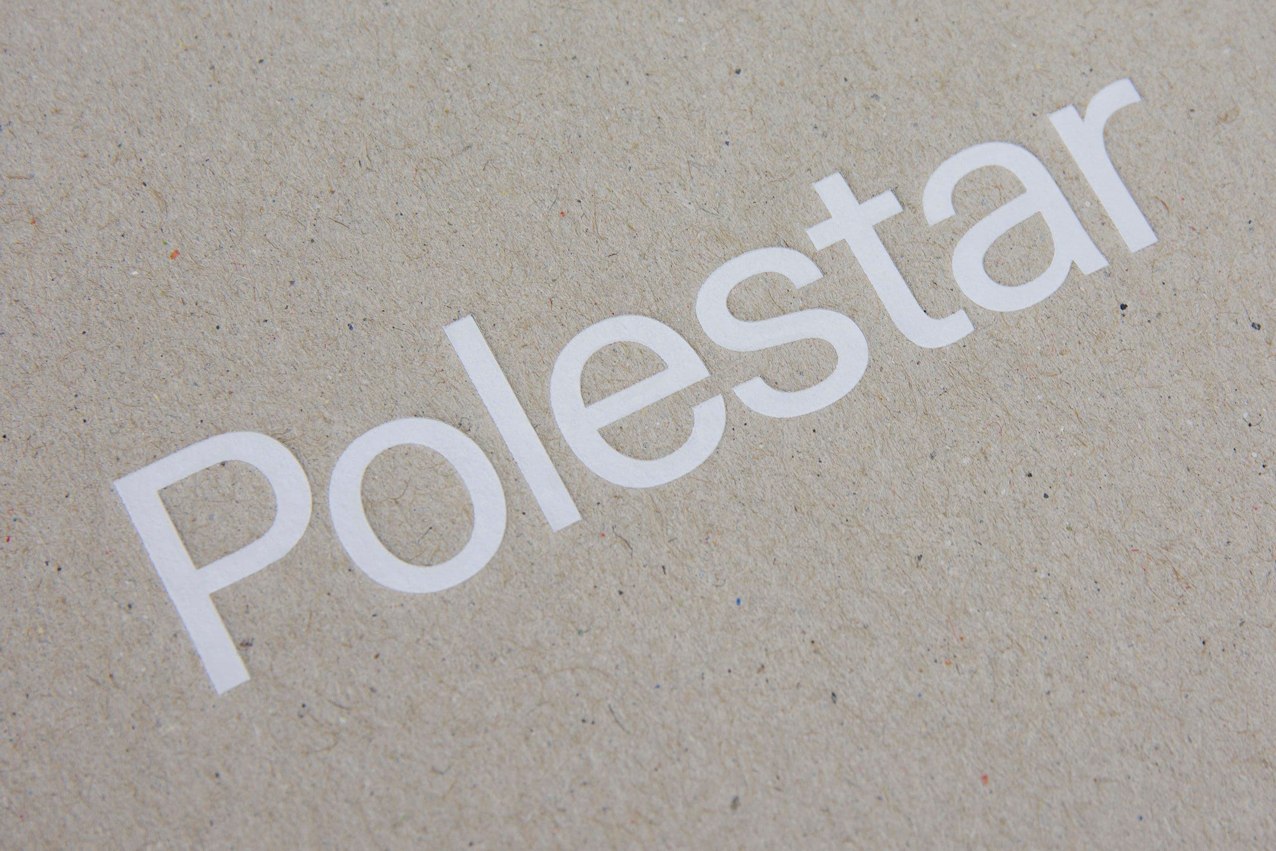 Close-up of premium logo printing on textured kraft paper packaging, showcasing high-quality brand application and sustainable print solutions. The image highlights crisp white typography on natural recycled board, demonstrating precision printing, eco-friendly materials, and luxury minimalist packaging design. Ideal representation of custom branding, sustainable packaging production, and multi-solution print services for retail and corporate brands.