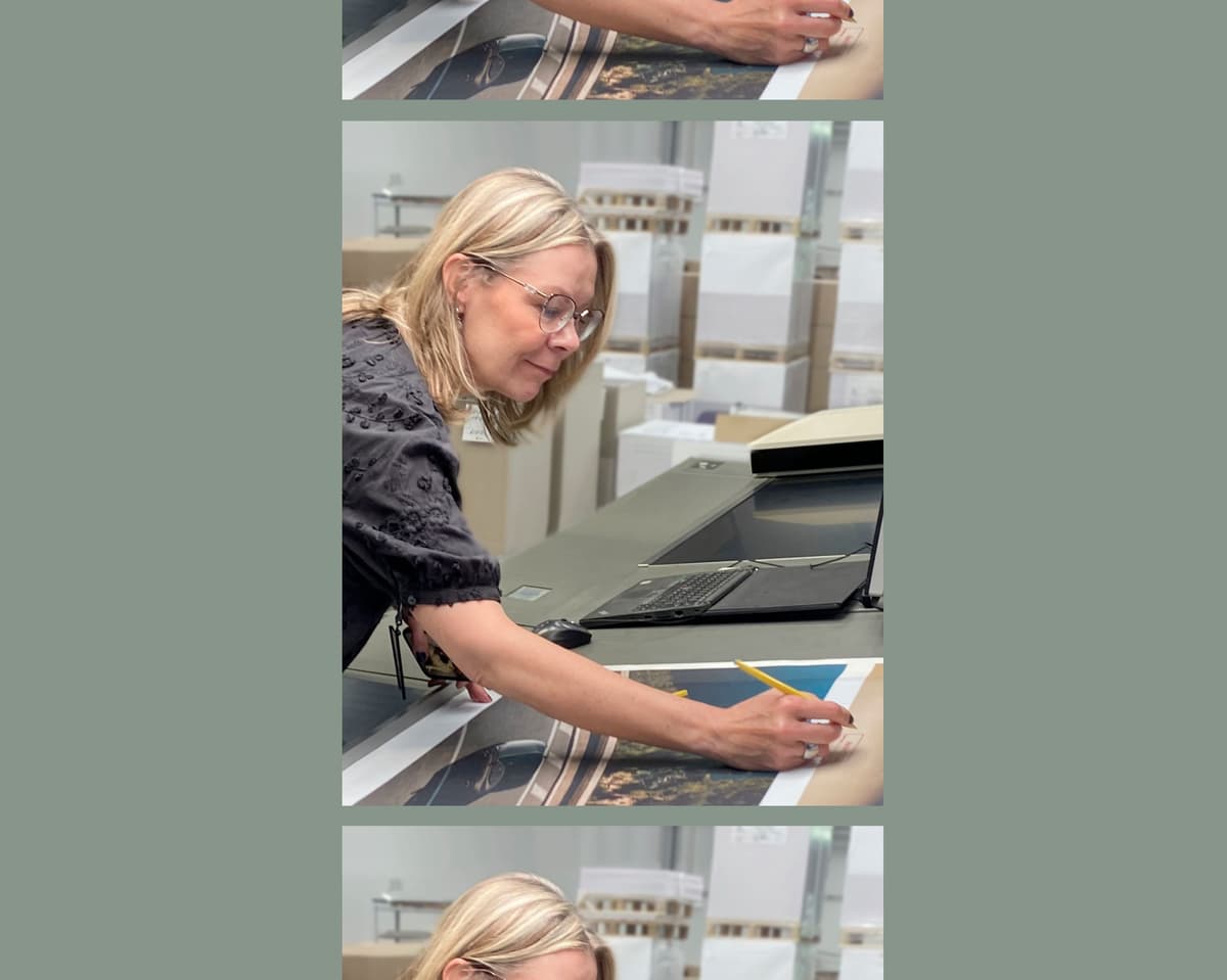 This high-quality image showcases the meticulous quality control and expert craftsmanship defining a leading European multi-services brand in print and packaging. The scene captures a happy client partner conducting a detailed review of high-resolution car photography prints, emphasizing the brand's commitment to color accuracy and fine detail.